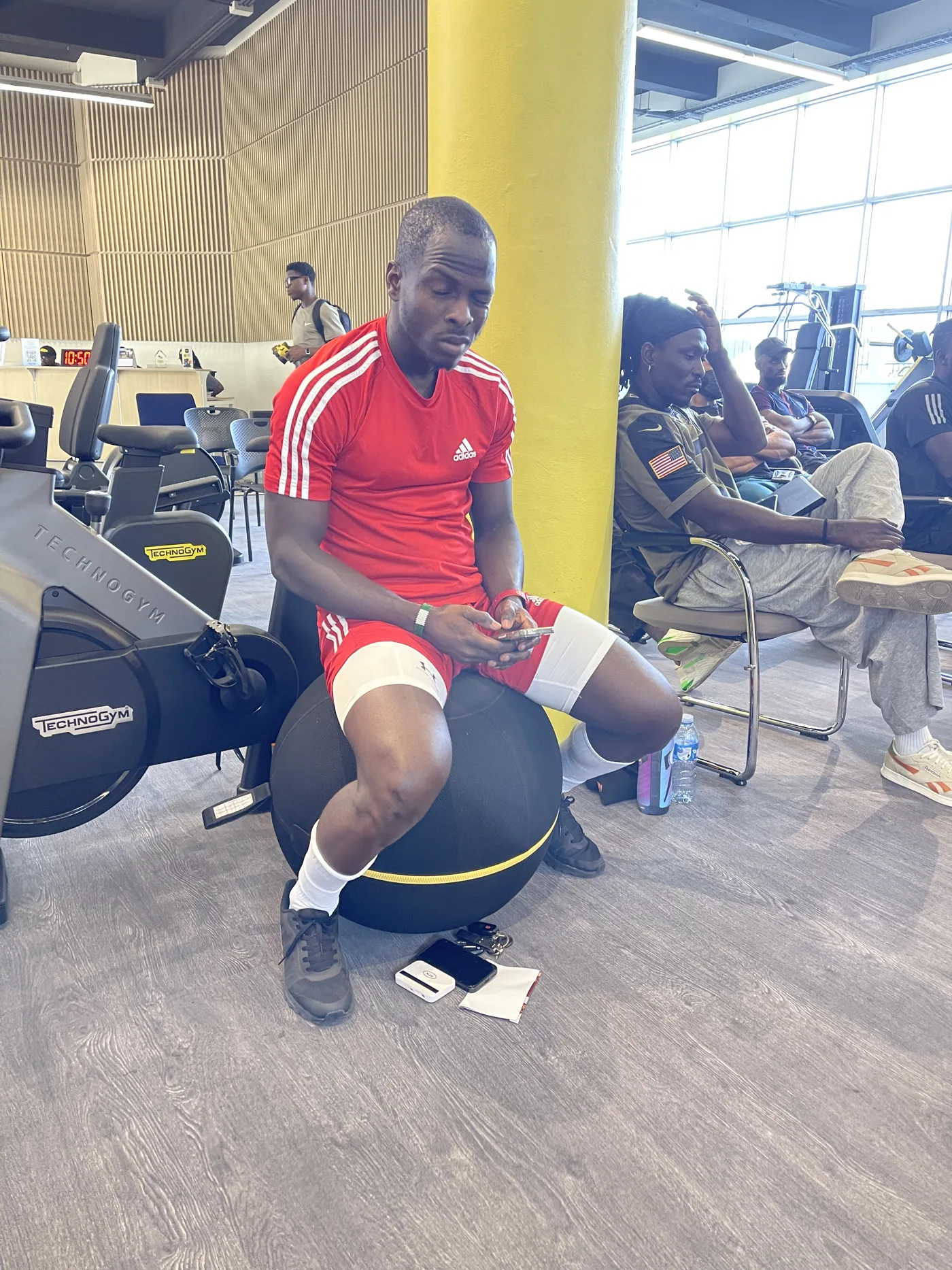 A participant balancing on a stability ball beside Technogym equipment